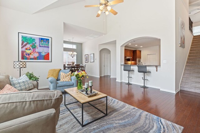 9905 Palmbrook Dr, Austin, TX 78717 - living room featuring a ceiling fan, dark wood-style floors, arched walkways, stairs, and a chandelier