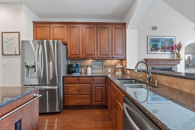 9905 Palmbrook Dr, Austin, TX 78717 - kitchen with stainless steel appliances, a sink, dark wood-type flooring, dark stone countertops, and brown cabinets