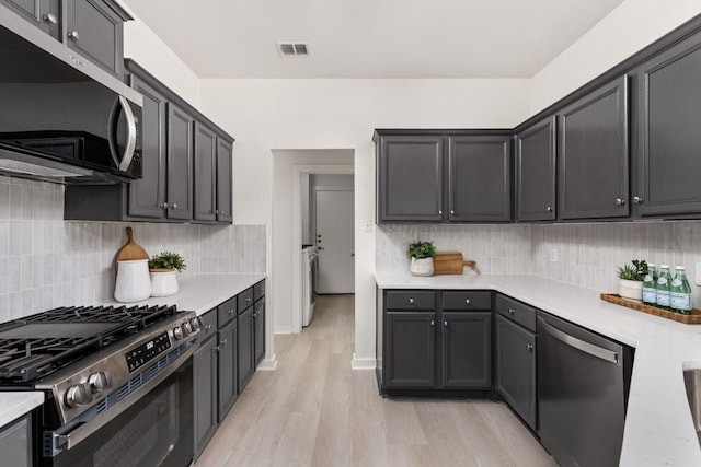 8005 Willet Trl, Austin, TX 78745 - kitchen with appliances with stainless steel finishes, light countertops, light wood-style flooring, and backsplash
