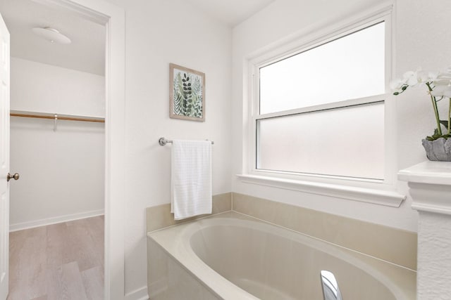 8005 Willet Trl, Austin, TX 78745 - full bathroom featuring a garden tub, a spacious closet, and wood finished floors