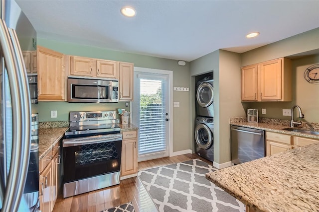2000 Lightsey Rd Unit 3, Austin, TX 78704 - kitchen with appliances with stainless steel finishes, light brown cabinetry, stacked washer / drying machine, a sink, and light wood finished floors