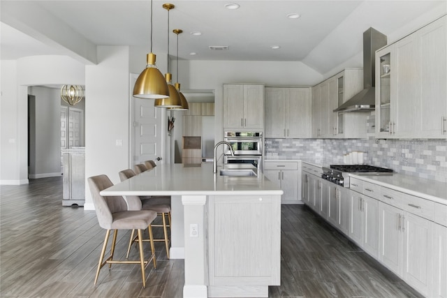 941 Linden Loop, Driftwood, TX 78619 - kitchen with wall chimney range hood, appliances with stainless steel finishes, decorative backsplash, a kitchen bar, and light countertops