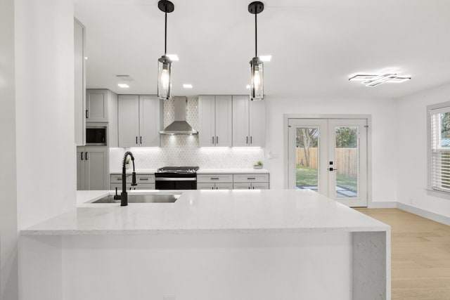500 Arbor Ln, Austin, TX 78745 - kitchen with a sink, wall chimney range hood, stainless steel range, decorative backsplash, and french doors