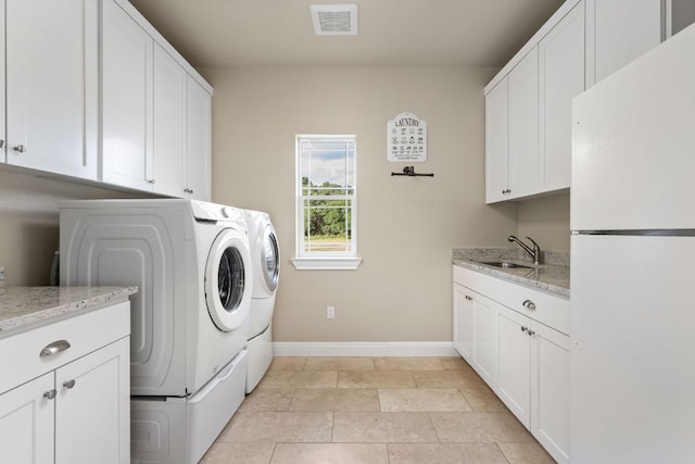 137 Lone Cypress Cv, Driftwood, TX 78619 - laundry area with separate washer and dryer, baseboards, cabinet space, and light tile patterned floors