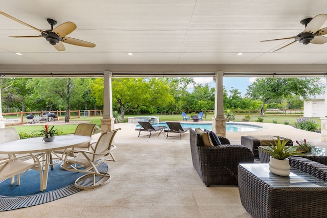 137 Lone Cypress Cv, Driftwood, TX 78619 - view of patio featuring a ceiling fan, a pool with connected hot tub, view of wooded area, and outdoor dining space