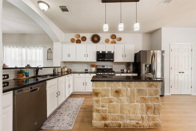 11113 Harvest Time Dr, Austin, TX 78754 - kitchen featuring appliances with stainless steel finishes, a sink, arched walkways, and light wood-style flooring