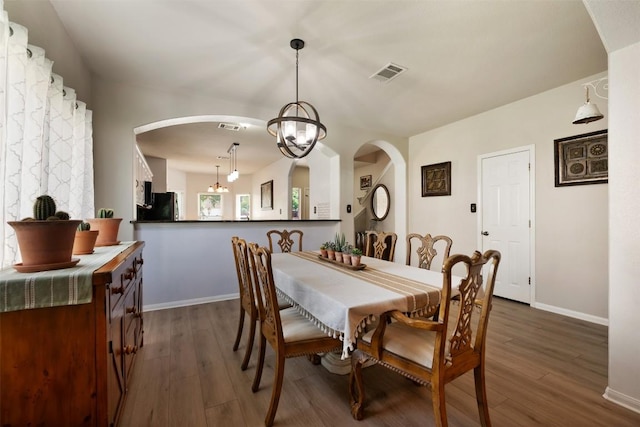 11113 Harvest Time Dr, Austin, TX 78754 - dining room featuring arched walkways, dark wood-style flooring, and baseboards