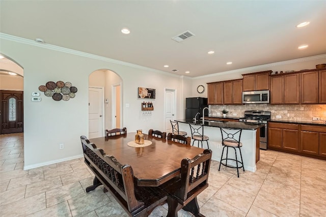 2712 Auburn Chestnut Ln, Pflugerville, TX 78660 - dining space featuring arched walkways, crown molding, recessed lighting, and baseboards