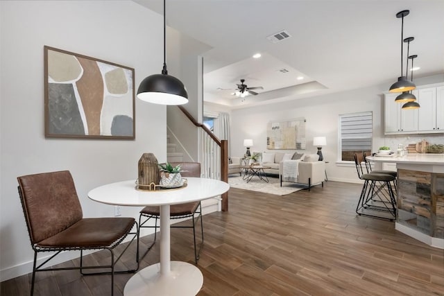 200 Wild Sage Ln, Liberty Hill, TX 78642 - dining room with stairs, a tray ceiling, dark wood-type flooring, baseboards, and recessed lighting