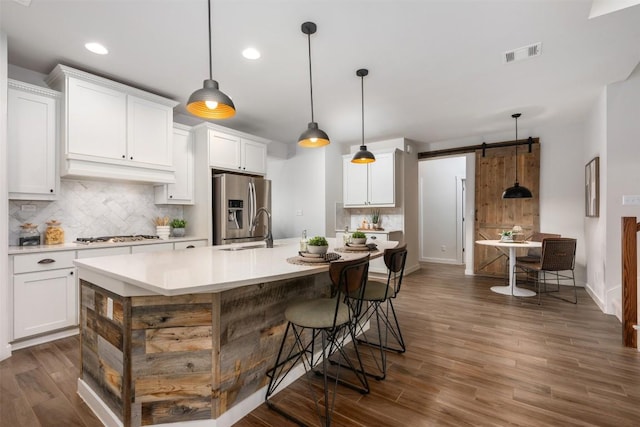 200 Wild Sage Ln, Liberty Hill, TX 78642 - kitchen with stainless steel fridge, a barn door, a sink, backsplash, and recessed lighting