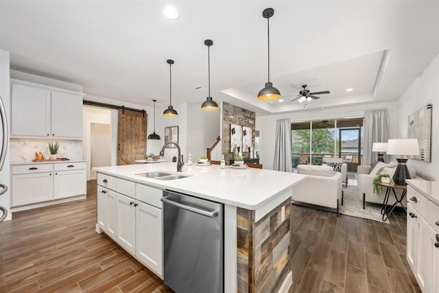 200 Wild Sage Ln, Liberty Hill, TX 78642 - kitchen with stainless steel dishwasher, a sink, dark wood-style flooring, a tray ceiling, and ceiling fan