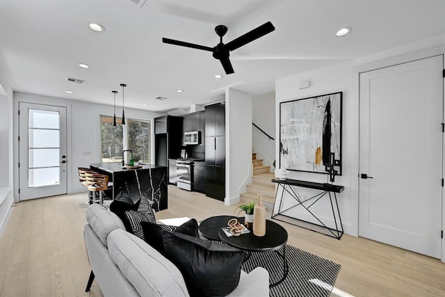 1117 Lawson Ln Unit 2, Austin, TX 78702 - living room with a ceiling fan, light wood finished floors, stairway, and recessed lighting