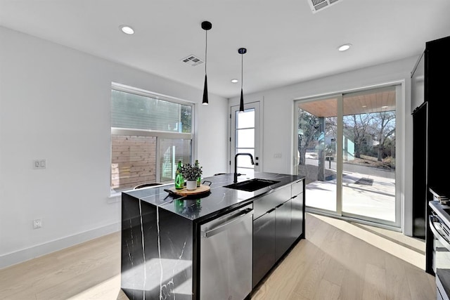 1117 Lawson Ln Unit 2, Austin, TX 78702 - kitchen featuring stainless steel appliances, a sink, dark cabinets, light wood-style flooring, and recessed lighting