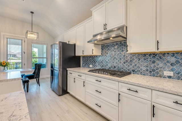 603 Arundel Rd, Austin, TX 78738 - kitchen with under cabinet range hood, stainless steel appliances, vaulted ceiling, backsplash, and light wood finished floors