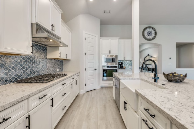 603 Arundel Rd, Austin, TX 78738 - kitchen featuring stainless steel appliances, under cabinet range hood, a sink, and white cabinets
