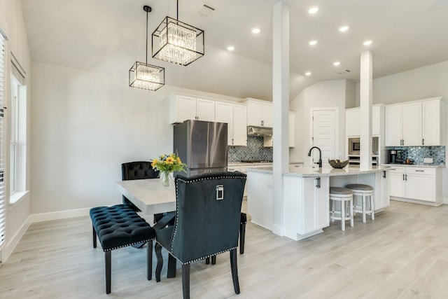 603 Arundel Rd, Austin, TX 78738 - dining space with lofted ceiling, light wood-type flooring, a chandelier, baseboards, and recessed lighting