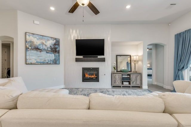 603 Arundel Rd, Austin, TX 78738 - living room featuring arched walkways, ceiling fan, a fireplace, baseboards, and recessed lighting