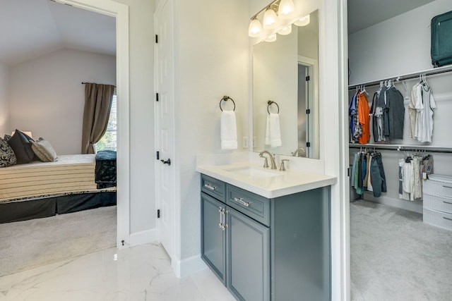 603 Arundel Rd, Austin, TX 78738 - bathroom featuring vanity, baseboards, lofted ceiling, a spacious closet, and marble finish flooring