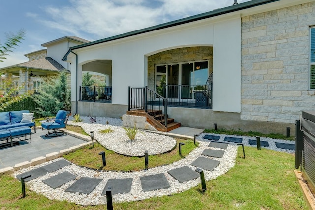 603 Arundel Rd, Austin, TX 78738 - view of property exterior with an outdoor living space, stone siding, stucco siding, and a patio