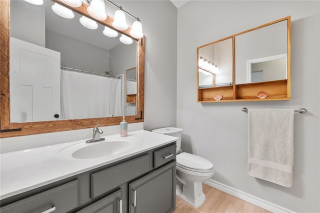 208 Sailors Run, Lakeway, TX 78734 - bathroom featuring wood finished floors, toilet, vanity, and baseboards