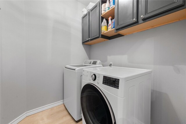 208 Sailors Run, Lakeway, TX 78734 - laundry area featuring cabinet space, washing machine and clothes dryer, light wood finished floors, and baseboards