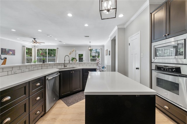 208 Sailors Run, Lakeway, TX 78734 - kitchen with a sink, appliances with stainless steel finishes, a chandelier, crown molding, and light countertops