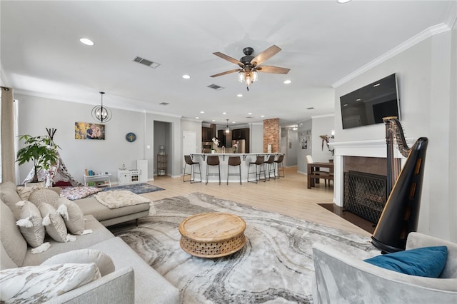 208 Sailors Run, Lakeway, TX 78734 - living room with crown molding, ceiling fan, light wood-type flooring, recessed lighting, and a fireplace with flush hearth