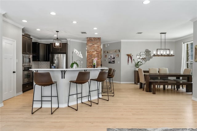 208 Sailors Run, Lakeway, TX 78734 - kitchen featuring appliances with stainless steel finishes, light wood-type flooring, a kitchen bar, light countertops, and recessed lighting