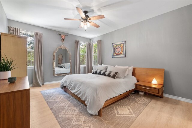 208 Sailors Run, Lakeway, TX 78734 - bedroom featuring multiple windows, light wood finished floors, baseboards, and a ceiling fan
