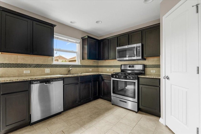 163 Wainscot Oak Way, San Marcos, TX 78666 - kitchen featuring stainless steel appliances, light stone counters, a sink, backsplash, and recessed lighting
