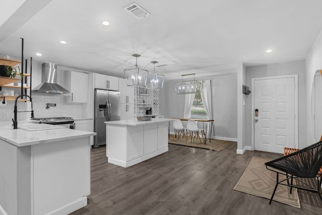 609 Blackberry Dr, Austin, TX 78745 - kitchen featuring stainless steel appliances, wall chimney range hood, white cabinets, backsplash, and dark wood finished floors