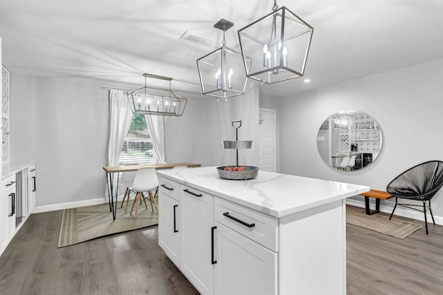 609 Blackberry Dr, Austin, TX 78745 - kitchen with a chandelier, a kitchen island, white cabinetry, wood finished floors, and recessed lighting