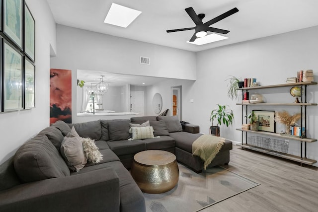 609 Blackberry Dr, Austin, TX 78745 - living room with a skylight, wood finished floors, a chandelier, and ceiling fan