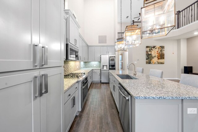 121 Cartwheel Bnd Unit 42, Austin, TX 78738 - kitchen with appliances with stainless steel finishes, a sink, a high ceiling, a center island with sink, and tasteful backsplash