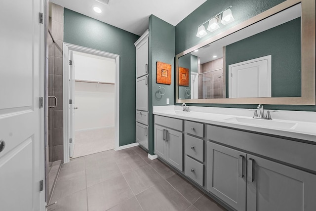 121 Cartwheel Bnd Unit 42, Austin, TX 78738 - full bath featuring a shower stall, double vanity, a spacious closet, and tile patterned floors
