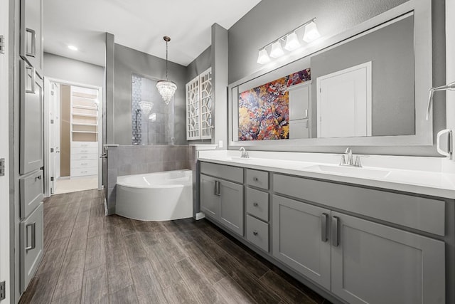 121 Cartwheel Bnd Unit 42, Austin, TX 78738 - full bath featuring double vanity, a tub to relax in, wood finished floors, and a walk in closet