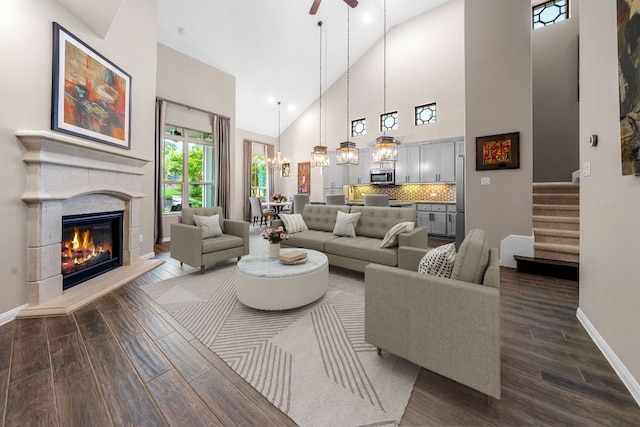 121 Cartwheel Bnd Unit 42, Austin, TX 78738 - living area featuring dark wood-type flooring, baseboards, high vaulted ceiling, a glass covered fireplace, and stairway