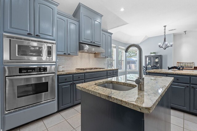 820 Morgan Hill Dr, Dripping Springs, TX 78620 - kitchen featuring stainless steel appliances, light tile patterned floors, light stone counters, a center island with sink, and recessed lighting