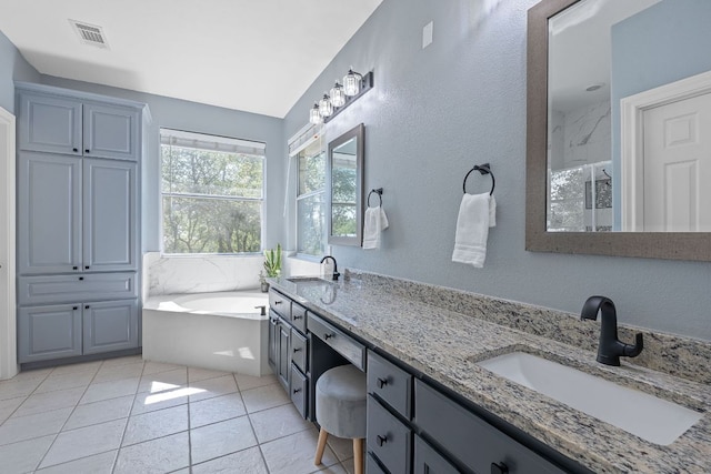 820 Morgan Hill Dr, Dripping Springs, TX 78620 - bathroom with a bath, double vanity, vaulted ceiling, a textured wall, and tile patterned flooring