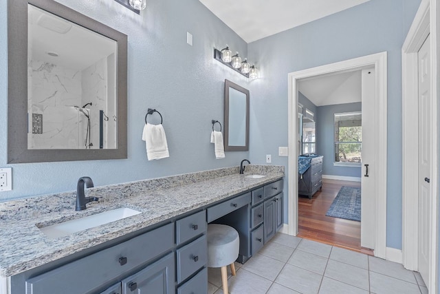 820 Morgan Hill Dr, Dripping Springs, TX 78620 - ensuite bathroom featuring double vanity, tile patterned flooring, a marble finish shower, and baseboards
