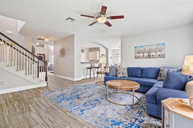 2021 Kimbrook Dr, Round Rock, TX 78681 - living area featuring arched walkways, a ceiling fan, stairs, baseboards, and wood finished floors