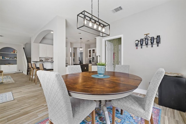 2021 Kimbrook Dr, Round Rock, TX 78681 - dining space featuring light wood-style flooring, arched walkways, and baseboards