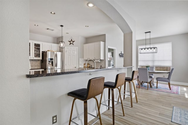 2021 Kimbrook Dr, Round Rock, TX 78681 - kitchen featuring stainless steel fridge, decorative backsplash, white cabinetry, glass insert cabinets, and recessed lighting