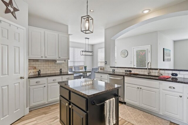 2021 Kimbrook Dr, Round Rock, TX 78681 - kitchen featuring stainless steel dishwasher, arched walkways, backsplash, white cabinets, and recessed lighting