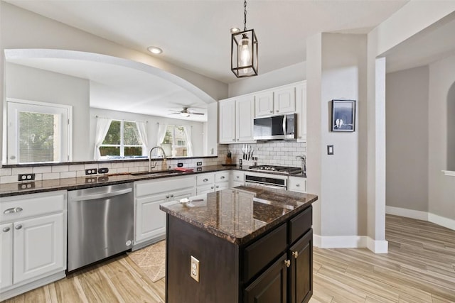 2021 Kimbrook Dr, Round Rock, TX 78681 - kitchen featuring stainless steel appliances, a sink, arched walkways, a ceiling fan, and backsplash