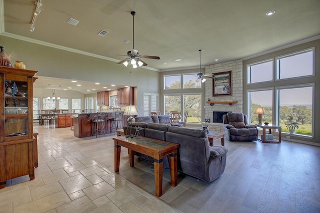 3514 Fm 3509, Burnet, TX 78611 - living area featuring crown molding, ceiling fan, a stone fireplace, plenty of natural light, and recessed lighting