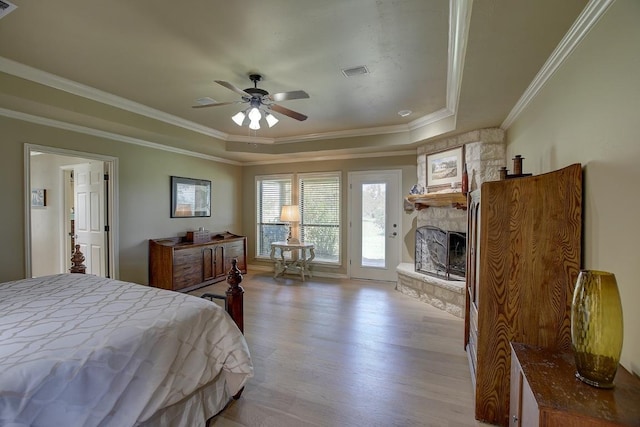 3514 Fm 3509, Burnet, TX 78611 - bedroom with access to exterior, a fireplace, light wood-style flooring, crown molding, and a raised ceiling