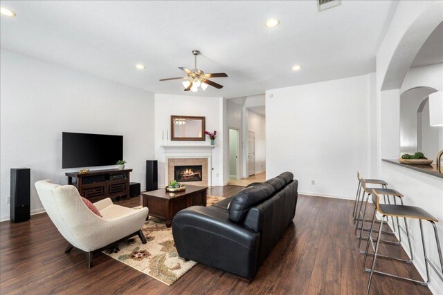 2709 Sun Mountain Dr, Leander, TX 78641 - living room with ceiling fan, recessed lighting, dark wood-style flooring, a warm lit fireplace, and arched walkways