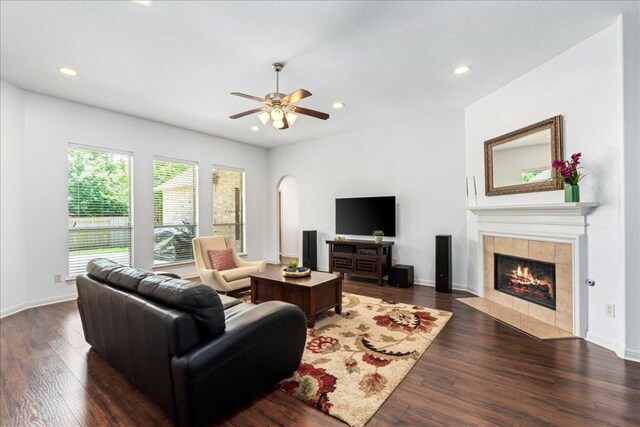 2709 Sun Mountain Dr, Leander, TX 78641 - living room featuring a tiled fireplace, arched walkways, recessed lighting, dark wood-type flooring, and ceiling fan