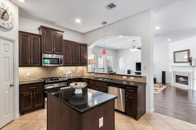 2709 Sun Mountain Dr, Leander, TX 78641 - kitchen with appliances with stainless steel finishes, ceiling fan, open floor plan, arched walkways, and tasteful backsplash